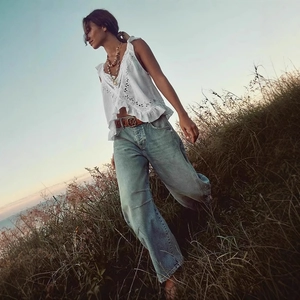 Détail d'un haut blanc sans manches avec broderie anglaise et volants de style boho