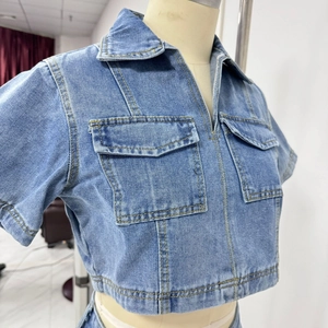 Detail of light blue denim crop top with cargo pockets and yellow contrast stitching