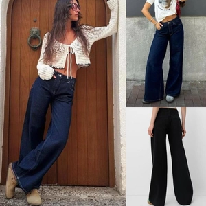 Détail du jean denim taille haute à jambes larges en coloris bleu foncé et noir délavé