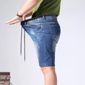 Detail showing elastic drawstring waistband and high stretch fabric of blue denim shorts