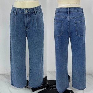 Détails d'un jean bleu large à taille haute montrant les plis avant et poches arrière