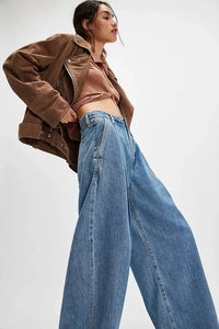 Détail d'un jean délavé à taille haute et jambe large avec une coupe vintage ample