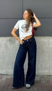 Photo de rue d'un jean large élégant porté avec un t-shirt blanc imprimé disco rétro