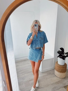 Women's light blue denim two-piece set with V-neck cropped top and irregular wrap skirt