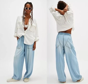 Detail of light blue wide-leg cargo jeans with large side pockets and elastic waist