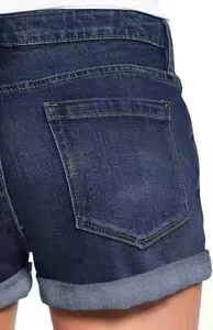 Detailed macro shot of dark blue denim shorts featuring cuffed hems and classic back pockets