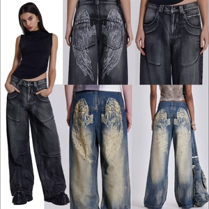 Vue détaillée du jean délavé vintage avec imprimés d'ailes et coupe large rétro