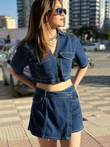 Women's dark blue denim two-piece set with cropped jacket and mini skirt with white stitching