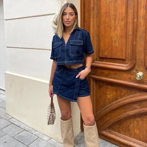 Detail view of dark blue denim two-piece set featuring V-neck cropped top and wrap mini skirt