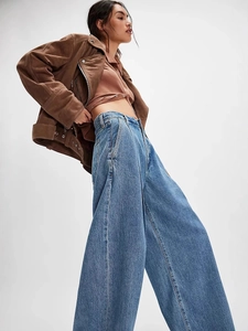 Jean large délavé vintage pour femme associé à une veste de motard en daim marron