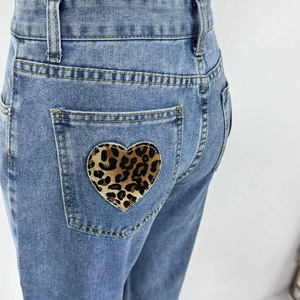 Detailaufnahme des Herz-Leopardenmusters auf der Tasche der blauen Denim-Jeans