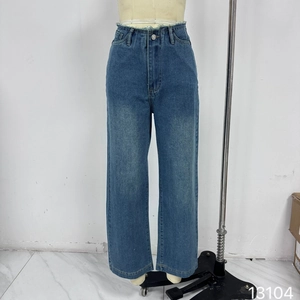 Détails d'un jean bleu taille haute à jambes larges avec délavage et bouton métallique