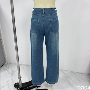 Détail du jean droit à taille haute avec bord brut à la taille et grandes poches plaquées