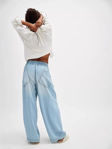 Women's light blue wide-leg denim pants featuring elastic high waist and large pockets