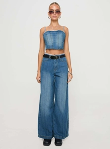 Détail d'un bustier en jean vintage à bords effilochés avec un jean large à taille haute assorti