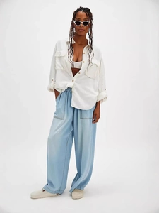 Women stylish loose straight leg jeans paired with white cotton shirt in studio