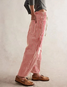 Detail of red and white striped wide-leg pants with drawstring waist and cargo side pocket