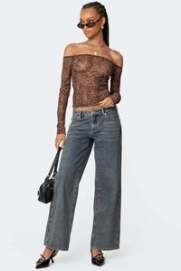 Detail einer High-Waist-Jeans mit weitem Bein und einem Langarm-Oberteil mit Leoprint