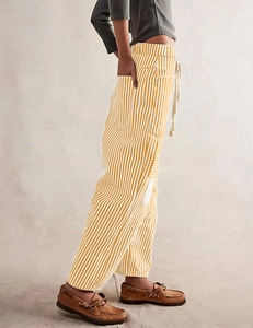 Detail view of yellow striped wide-leg pants with drawstring waist and side pockets
