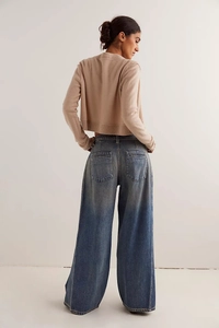 Dettaglio di jeans a gamba larga blu scuro con trama lavata e design tasca posteriore