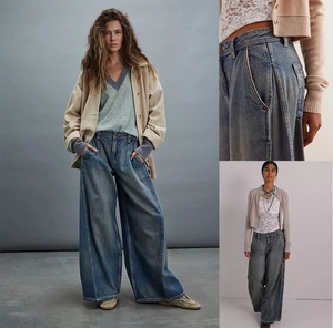 Dettaglio dei jeans blu lavato a gamba larga con vita alta e cuciture laterali ornamentali