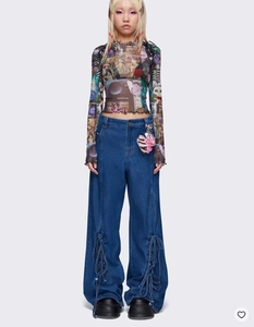 Détail du haut en mesh à imprimé vintage et du jean bleu large avec breloque cœur