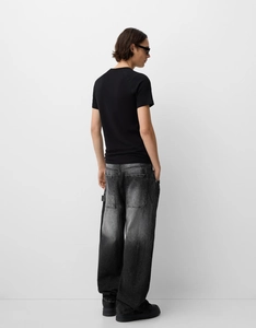 Back view of loose fit gradient denim jeans with distressed finish and wide leg cut