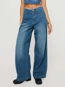 Détail du jean large à taille haute avec ceinture à bords francs et denim bleu délavé