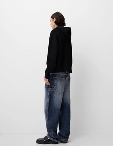 Detail view of retro slim fit blue denim jeans with vintage wash and distressed texture