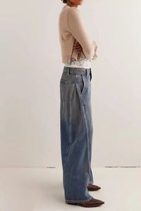 Dettaglio dei jeans a vita alta a gamba larga con lavaggio vintage e tasche laterali