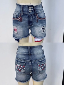 Detail view of high waist denim shorts with US flag embroidery and distressed hem finish