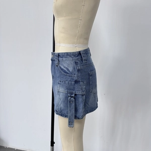 Détail de jupe en jean taille haute avec grandes poches latérales et sangles à boucles