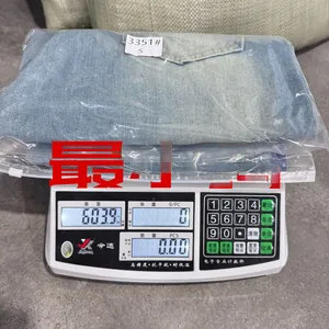 Detail showing high-waisted wide-leg jeans in light blue weighing 603.9g on digital scale