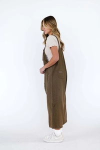 Detail of dark brown cargo overall dress with raw hem and functional side pockets