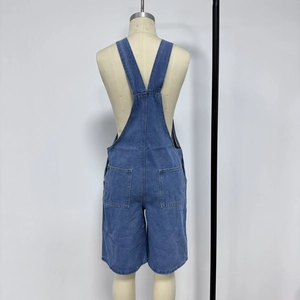 Detailed back view of blue denim overall shorts with cross straps and square pockets