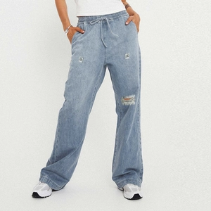 Detail of light blue wide leg jeans with elastic drawstring waist and ripped knee accents