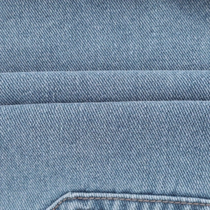 Gros plan sur la texture du denim bleu clair et les détails de couture du short décontracté
