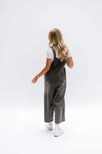 Rear view of loose vintage grey denim overalls with distressed back pocket detail