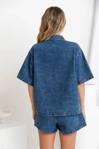 Vista posteriore di un set denim retrò da donna con camicia e pantaloncini elastici