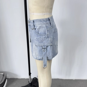 Détail d'une jupe cargo en jean bleu clair avec poches à soufflet et boucles en D