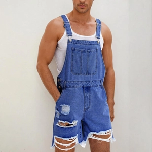 Détail d'une salopette en jean bleu clair avec déchirures et boucles métalliques