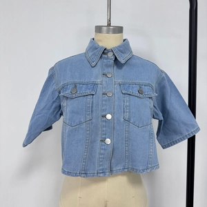Detail view of light blue short sleeve denim jacket with metal buttons and chest pockets