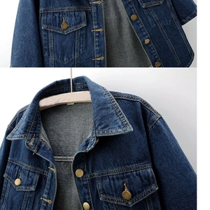 Detail view of denim jacket showing yellow contrast stitching and vintage metal buttons