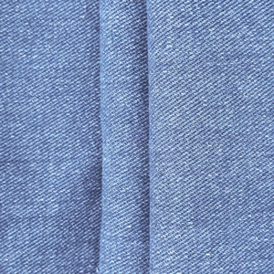 Macro detail of dark blue denim fabric with visible twill weave and durable texture
