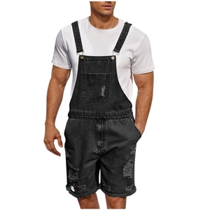 Detail of distressed ripped denim texture and metal buckle on men's black overall shorts