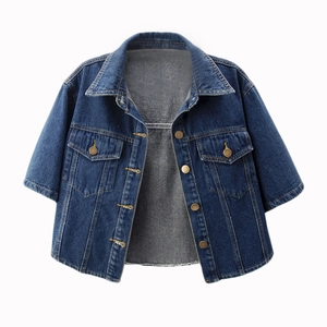 Detail of dark blue denim short jacket featuring metallic buttons and chest pockets