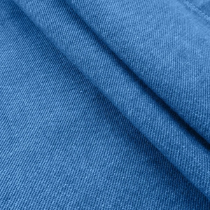 Macro shot of premium blue denim fabric showing twill weave and cotton texture detail