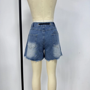 Detail of light blue denim shorts featuring frayed hems and back pockets on mannequin
