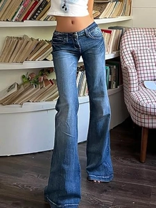 Close-up of retro flare jeans featuring vintage cat whisker texture and faded wash detail