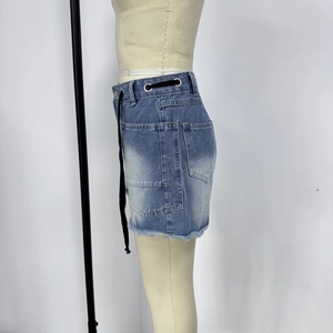 Detail of high-waisted denim skirt with metal eyelets, drawstring and cargo side pocket